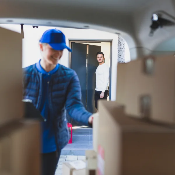 Un homme et une femme dans une voiture chargée de cartons, prêts pour un déménagement local.