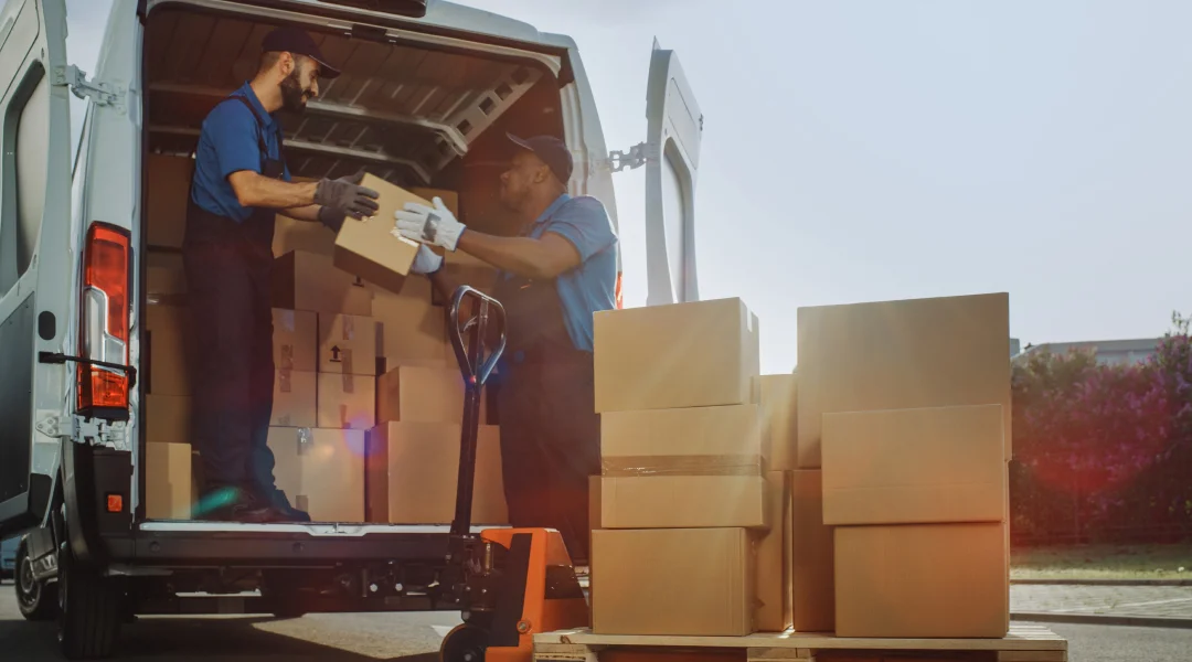 Deux hommes déchargent des cartons d'un camion de déménagement.